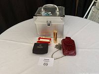 Full lot overview showing silver train case on table with five accessory items arranged in front.