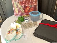 Overview photo showing all items laid out on the table including cutting boards, Tupperware, towels, candle holder, and fabric pieces.