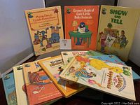 Overview of all nine Sesame Street books arranged on a table, showing front covers including Prairie-Dawn's Upside-Down Poem, Grover's Book of Cute Little Baby Animals, Show and Tell, and more.