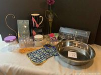 Photo showing the metal pet bowl, floral oven mitt and pot holder, jars, incense sticks, and decorative items