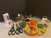 Overview of the lot showing all the kitchen gadgets including scissors, juicer, spice jars, UVC sanitizers, and other utensils