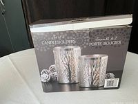 Box showing set of 2 silver candle holders with tree branch design, new in box