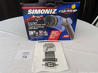Simoniz Cyclone PowerSpin tool packaging box with product image and instruction manual laid in front.