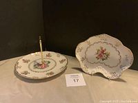 Two vintage Foley dishware pieces displayed on a surface with gold rims and floral designs, one with a central gold handle