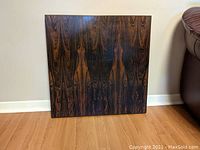 Front view of the square rosewood coffee table top showing the symmetrical bookmatched veneer pattern.