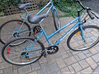 Side view of the light blue SuperCycle bike showing frame, seat, and rear wheel.