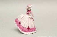 Front view of Coalport Beau Monde Jill porcelain figurine in pink and white Victorian-style dress with floral details and hat.