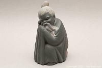 Front view of the Chinese Holy Man porcelain figurine showing facial features and robe details.