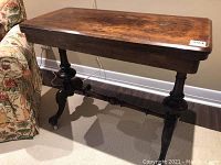 Front side view of table showing rectangular closed top and turned pedestal base