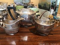 Overview of teapot, creamer, and sugar bowl grouped on tabletop