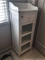 Full-angle view of cabinet showing tray top, drawer, glass door, beadboard sides and floor scale.