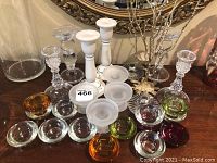 Group photo showing all candle holders on a wooden surface in front of ornate mirror and wall decor