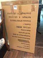 View of original large cardboard box with product and shipping details, showing dimensions and weight.