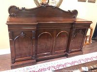 Front view of entire mahogany buffet with carved crest and paneled doors