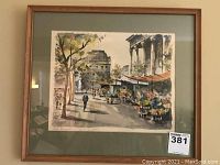 Front view of one framed Parisian street scene art print in brown wooden frame and green matting