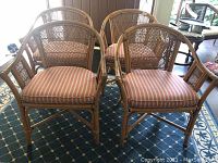 Front view of four rattan chairs with cushions on patterned rug