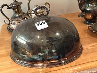 Front side view of the silver plated meat dome showing overall shape and reflective surface with some tarnish.