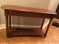 Front view of the solid wood console table showing the tabletop, turned legs, and lower shelf.