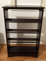 Front view of the wood CD rack showing shelves and dark finish