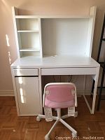Front view of white desk with attached bookshelf hutch and pink rolling chair
