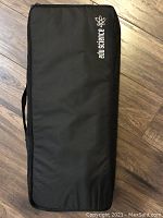 Closed black zippered carrying case with Edu Science logo on wooden floor