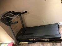 Side view of NordicTrack treadmill showing running deck, front motor housing and console