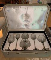Six smoked glass toasting snifters arranged in original fitted satin-lined case with emblem and text branding
