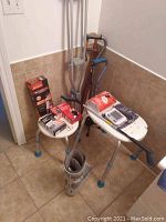 Overall view of the lot showing bath stools, walking sticks, crutches, blood pressure monitor, and medical accessories
