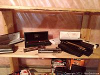 Multiple pens and cases displayed on wooden shelf