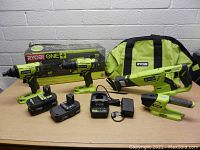 Full lot with all tools, batteries, charger and carrying bag arranged on a surface