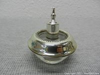 Close-up of vintage table lighter showing sterling silver top and clear crystal base with beaded edge detail.