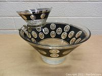 Chip and dip set, showing black and 22kt gold oval medallion decoration on clear glass.