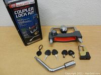 Photo of the new Tow Smart heavy duty high security coupler lock kit including the coupler lock, padlock, five keys, and wrench tool, displayed with original packaging box.