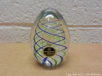Front view of the Artcristal crystal paperweight showing colorful spiral glass ribbons inside and the brand label.