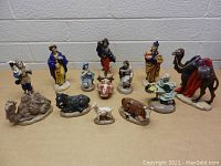 Group photo of all vintage nativity scene figures arranged on table showing variety of characters and animals included