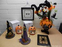 Full view of Halloween decorations including witch hats, jack-o'-lanterns, Trick or Treat cauldron, and framed art