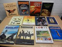 Full lot of ten hardcover books arranged in two rows on a tabletop