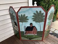 Three panel hand painted fireplace screen with farmhouse scenes, showing side and center panels in outdoor setting.