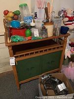 Kitchen cabinet with assorted kitchen items including jars, measuring cups, utensils, and containers.
