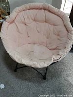 Front view of the pink cushioned round lounge chair.
