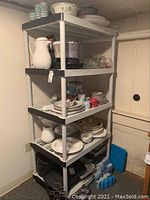 Plastic storage rack filled with various household items, shown from side angle to highlight structure and condition.