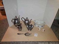 Full lot of silverplated tea and coffee set, pie server, porcelain casserole, and salt and pepper shakers