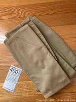 Folded vintage military caps stacked and displayed on wooden floor.