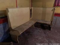 Two high top wooden benches placed in a basement corner showing overall condition and size.