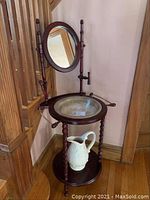 Full view of washstand with mirror and pitcher on bottom shelf