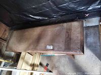 Top-down view of the rectangular wooden bench showing wear and surface discoloration.