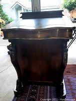Side view of desk showing carved pedestal base