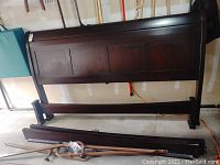 King size wooden headboard with dark panel finish shown from angle