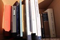 Photo showing 12 assorted books in an open box with visible titles including 'The Twilight Garden', 'Poetry of Robert Frost', and 'Down East The Fall River Reader'.