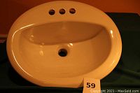 Front view of the white oval ceramic sink showing faucet holes and basin depth.